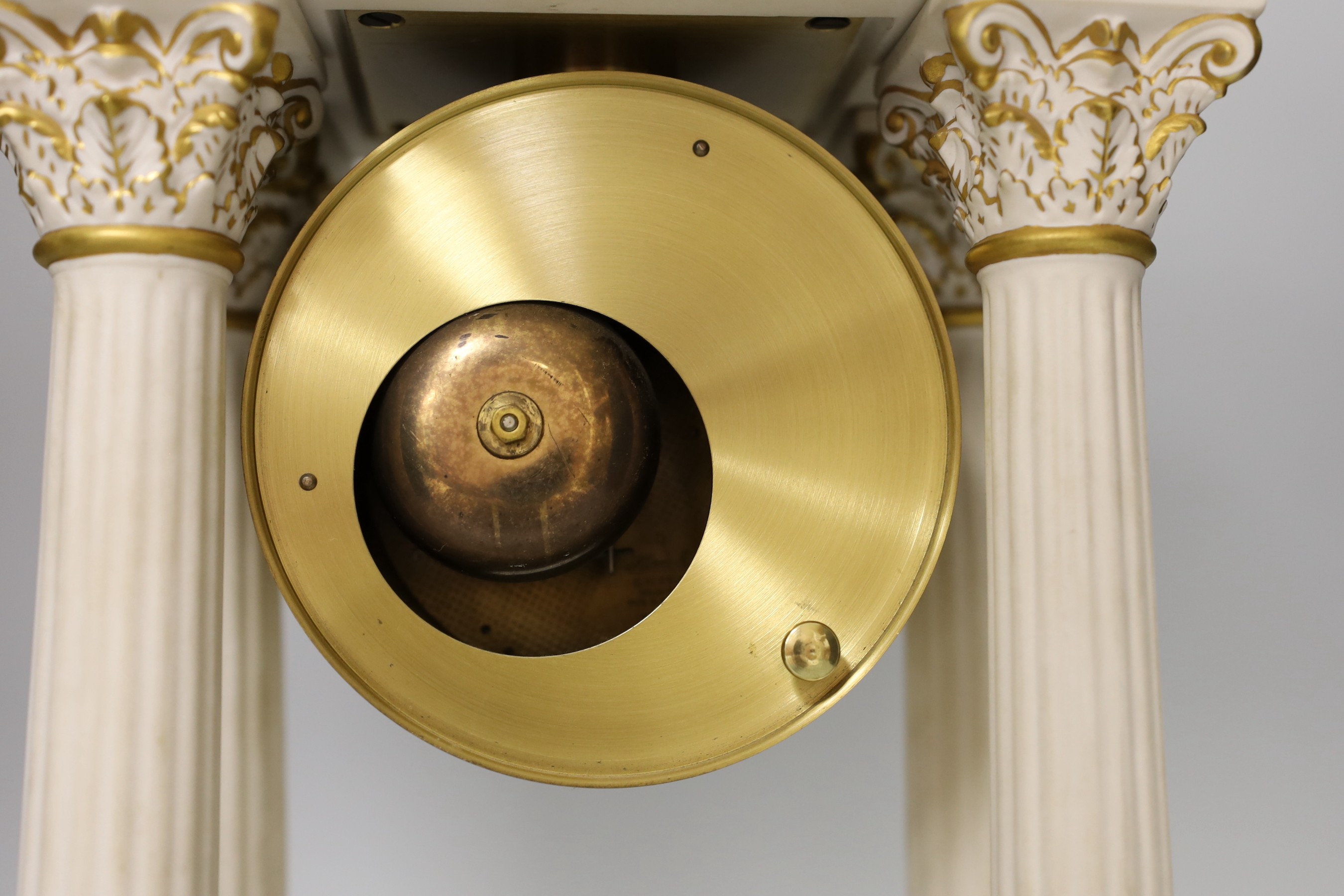 A modern ceramic portico column clock with floral and gilt decoration, with key and pendulum, 37cm tall